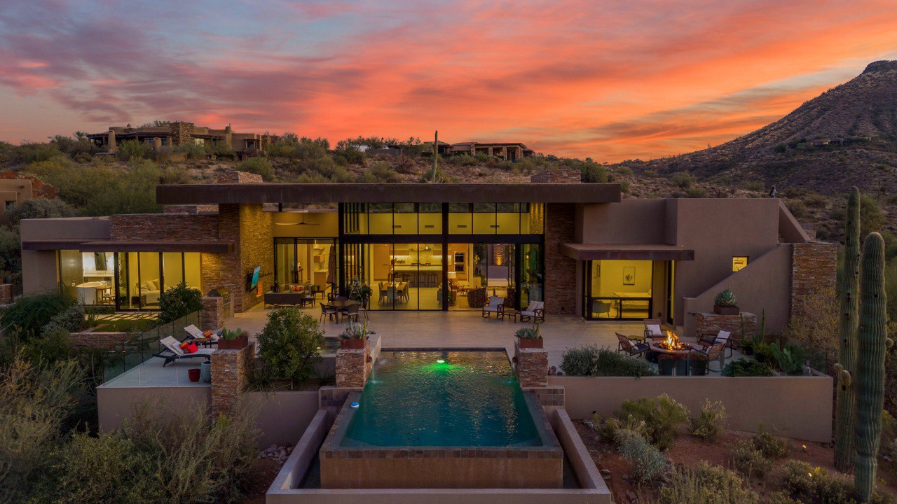 Desert home aerial with pool at sunset